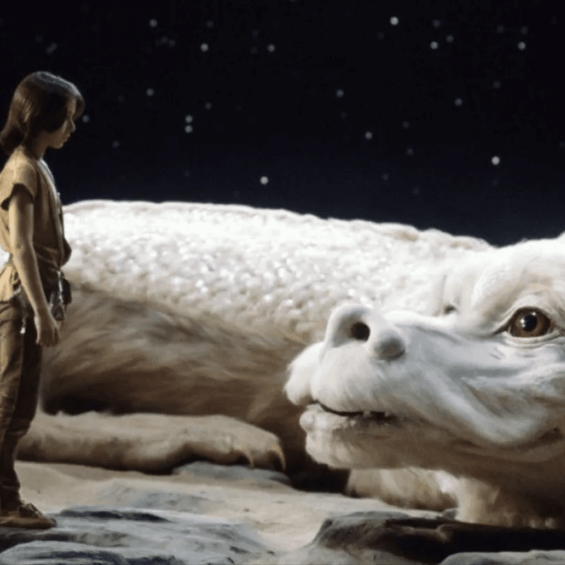 In a still from Neverending Story we see a boy, Atreyu, standing before a huge white dragon, Falcor, with a kind, smiling face that’s looking at him. It is night time.